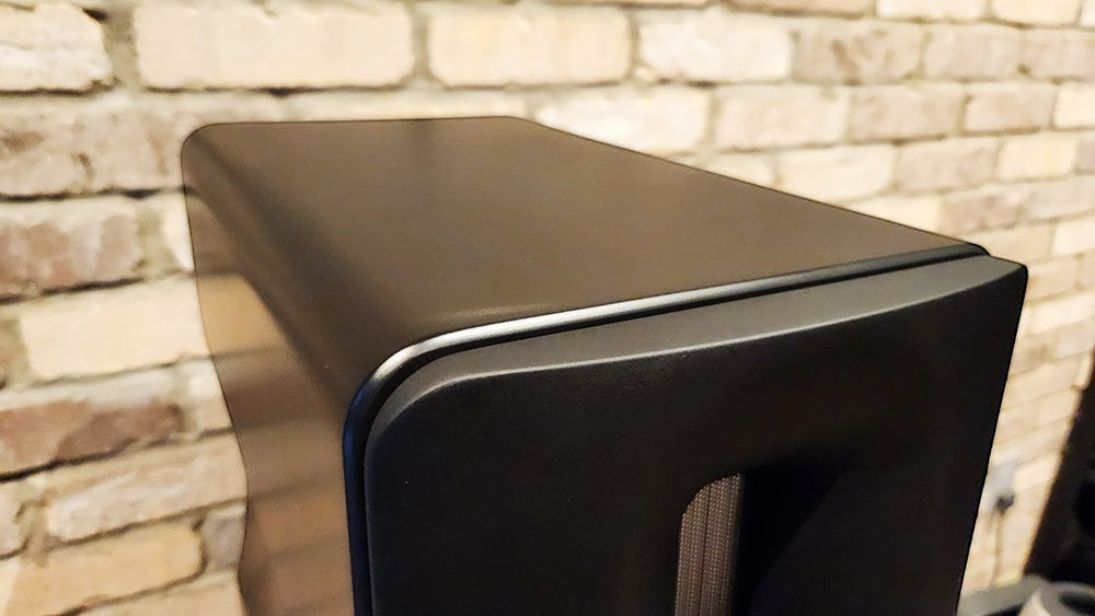 Salon 1 Audio Børresen Z3 floor standing loudspeaker in a sleek satin black finish against a rustic brick wall