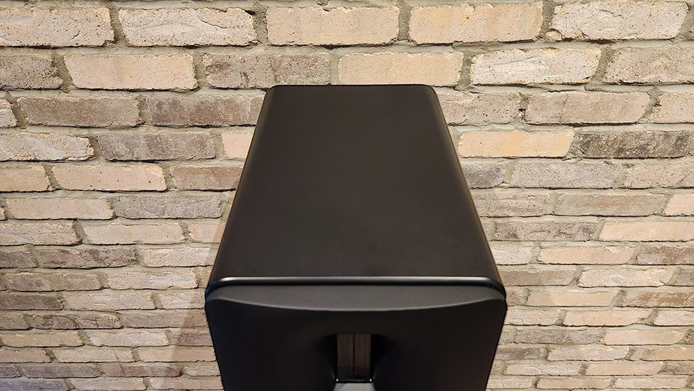 Salon 1 Audio Børresen Z3 floor standing loudspeaker in satin black finish viewed from the top against a brick wall.