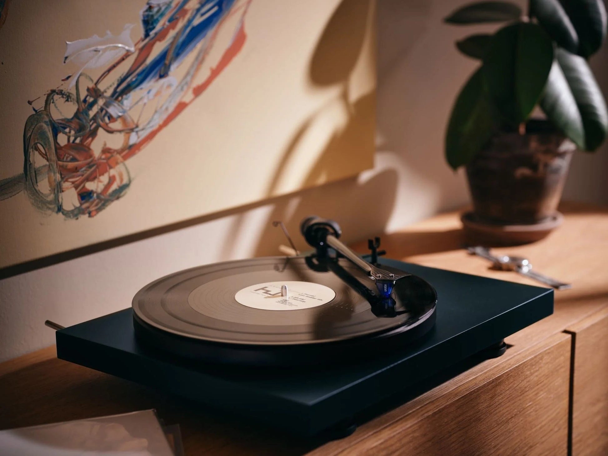 Salon 1 Audio Ortofon 2M Blue moving magnet cartridge installed on a turntable playing a vinyl record in a home setting
