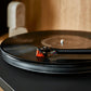 Salon 1 Audio Ortofon 2M Bronze stylus installed on a turntable tonearm playing a black vinyl record.