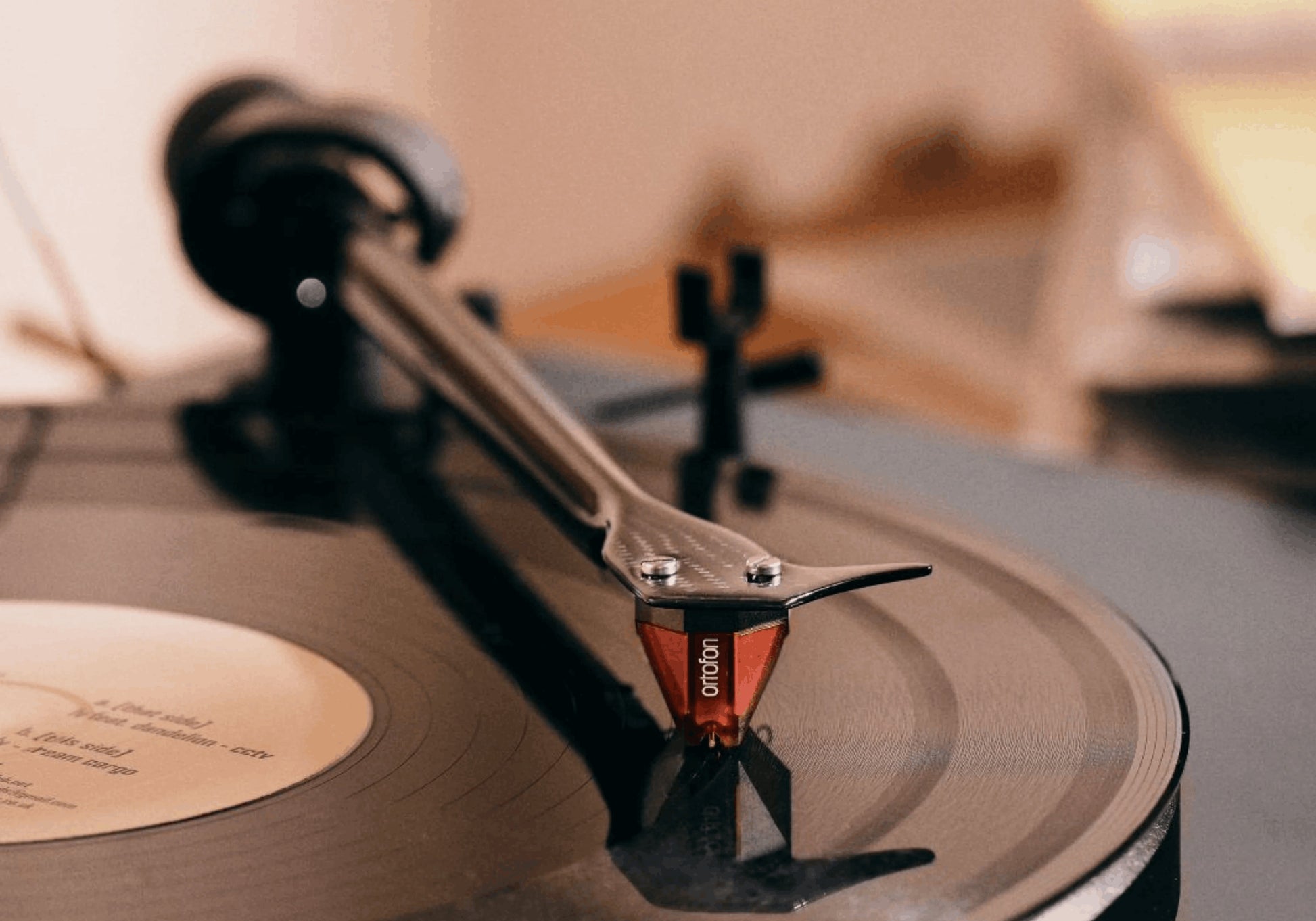 Salon 1 Audio Ortofon 2M Red moving magnet cartridge playing a black vinyl record on a turntable tonearm