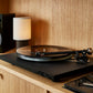 Salon 1 Audio Ortofon 2MR Black LVB 250 moving magnet cartridge installed on a turntable in a modern home setting.