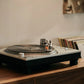 Salon 1 Audio Ortofon MC Quintet cartridge mounted on a silver turntable playing a vinyl record in a home setting