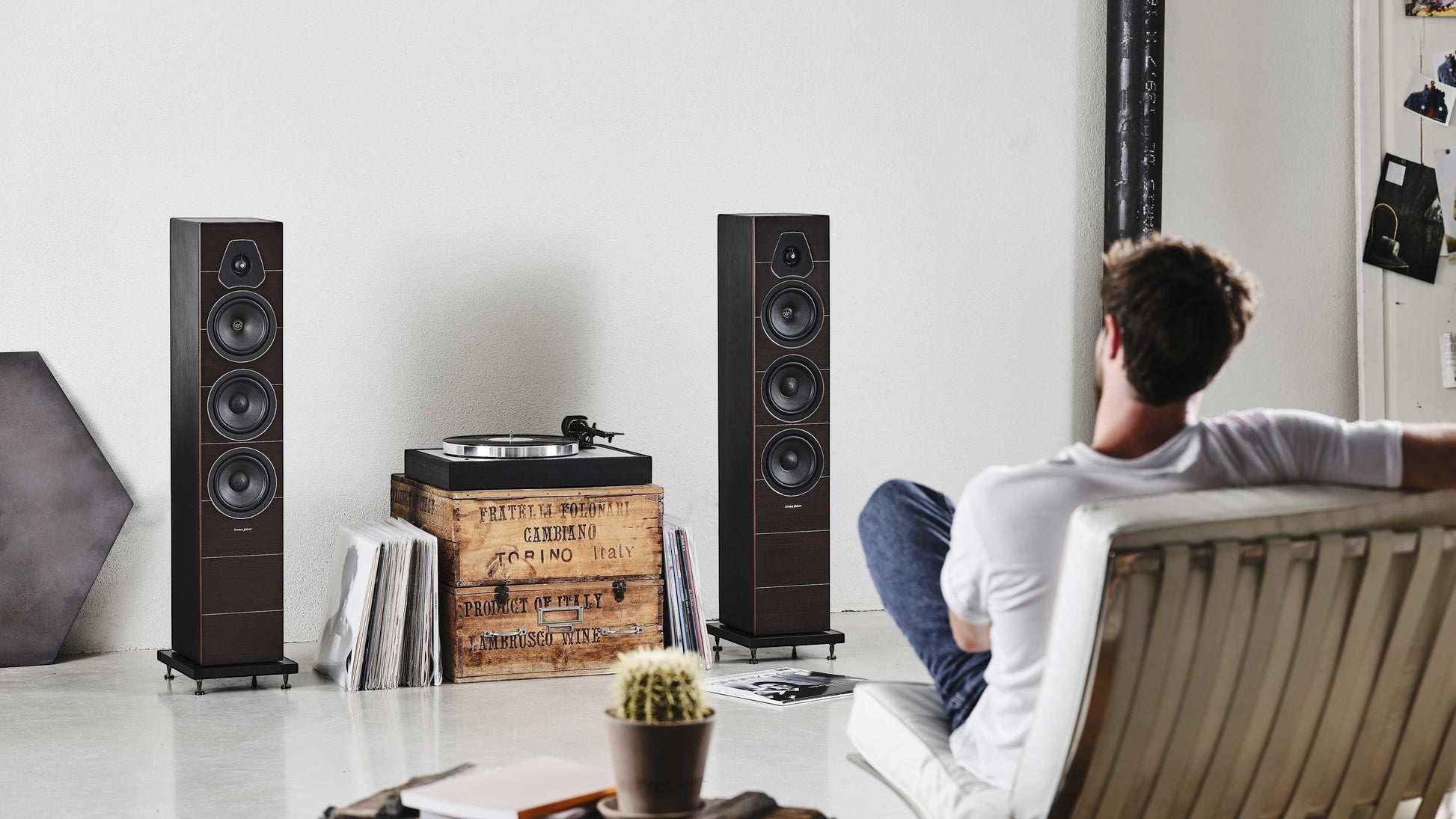 Salon 1 Audio Sonus faber Lumina III floorstanding speakers in a modern living room with a man listening to music.