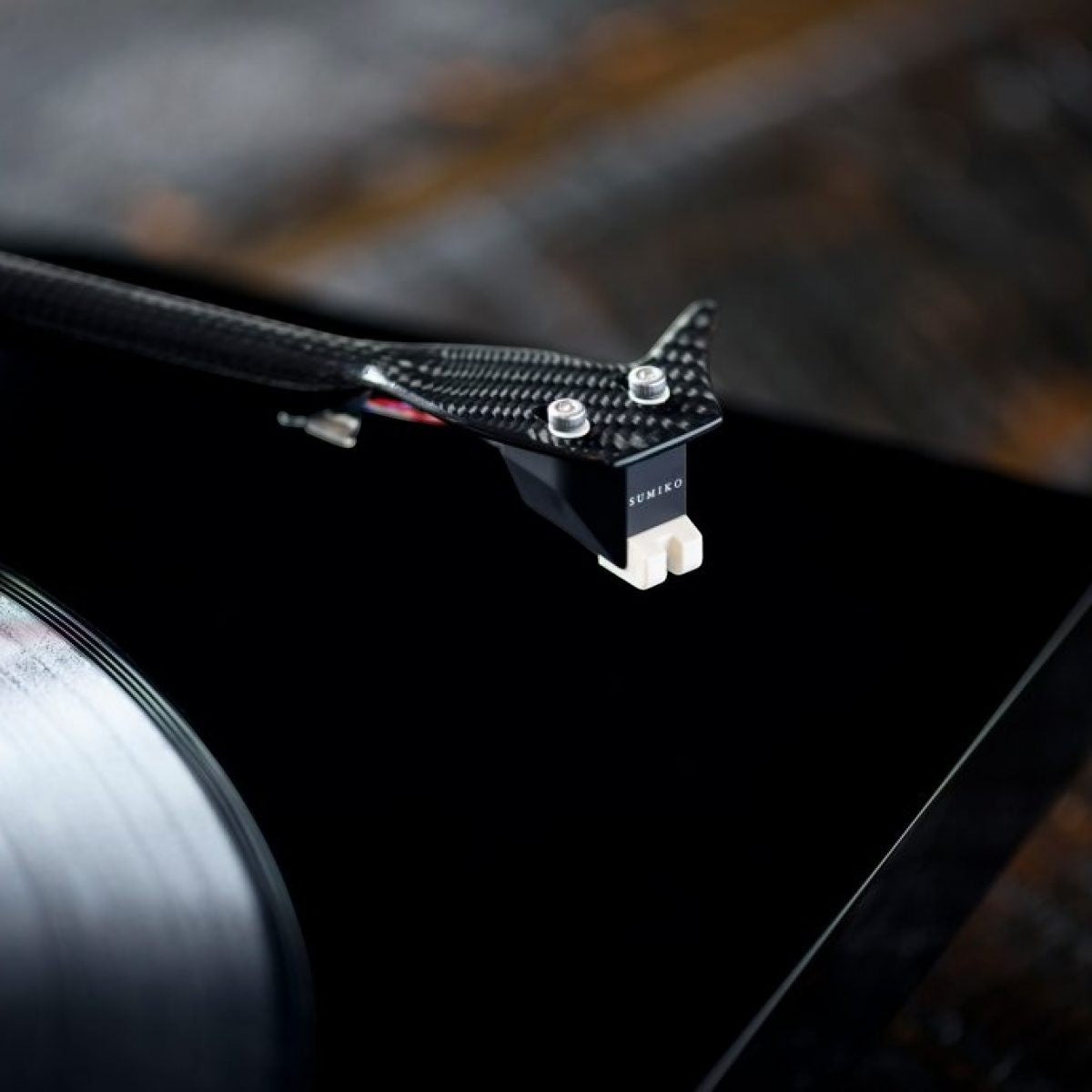 Salon 1 Audio Sumiko Amethyst moving magnet phono cartridge mounted on a carbon fiber tonearm above a vinyl record
