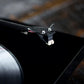 Salon 1 Audio Sumiko Rainier moving magnet phono cartridge mounted on a carbon fiber tonearm above a vinyl record.