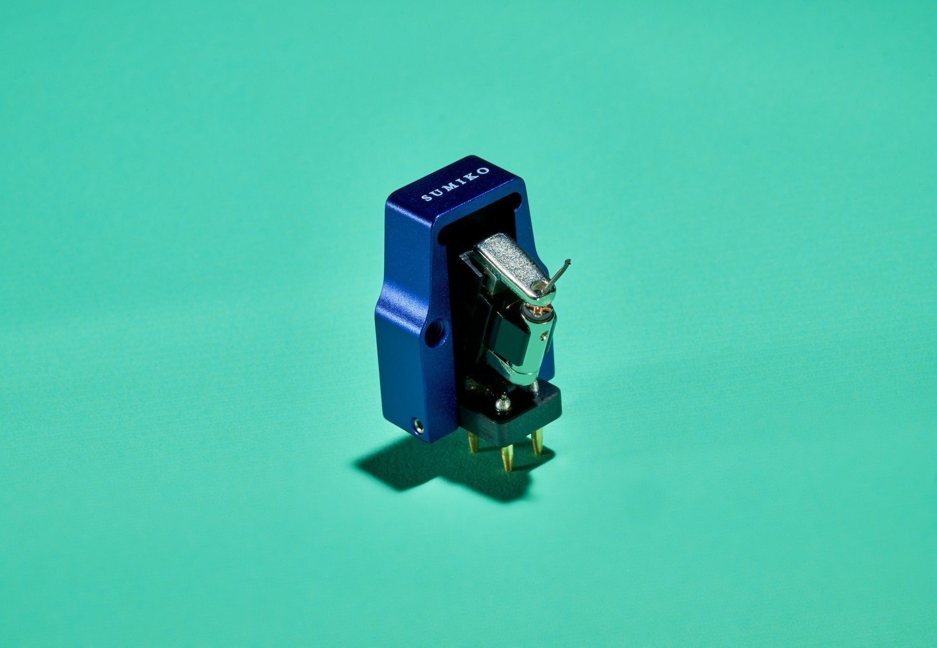 Salon 1 Audio Sumiko Songbird High output moving coil cartridge with a blue open-body design on a green background.
