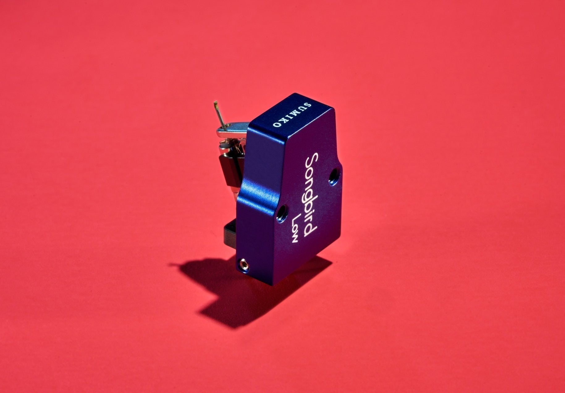 Salon 1 Audio Sumiko Songbird Low moving coil phono cartridge in blue with an open-body design on a red background.