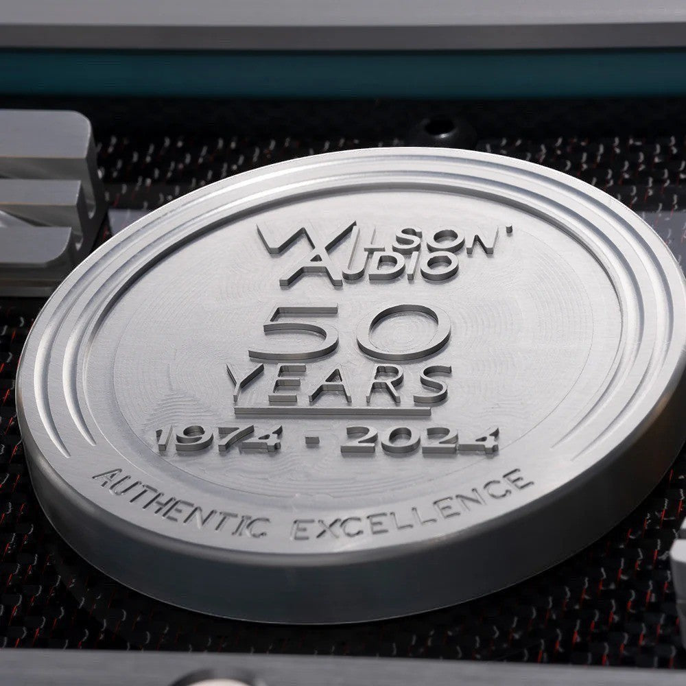 Salon 1 Audio Wilson Audio 50th anniversary commemorative metal emblem on a high-end loudspeaker cabinet.