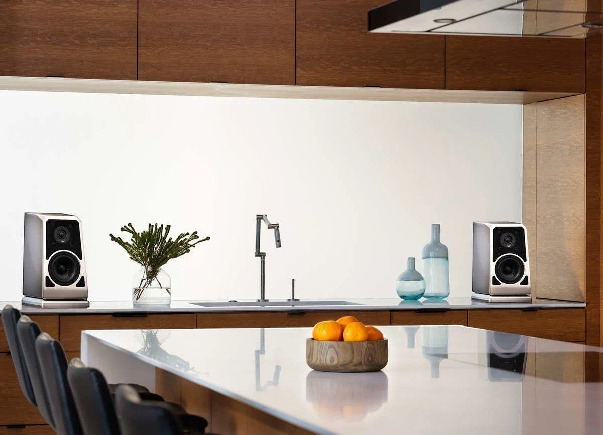 Salon 1 Audio Wilson Audio TuneTot bookshelf speakers in a modern kitchen setting on a white countertop.